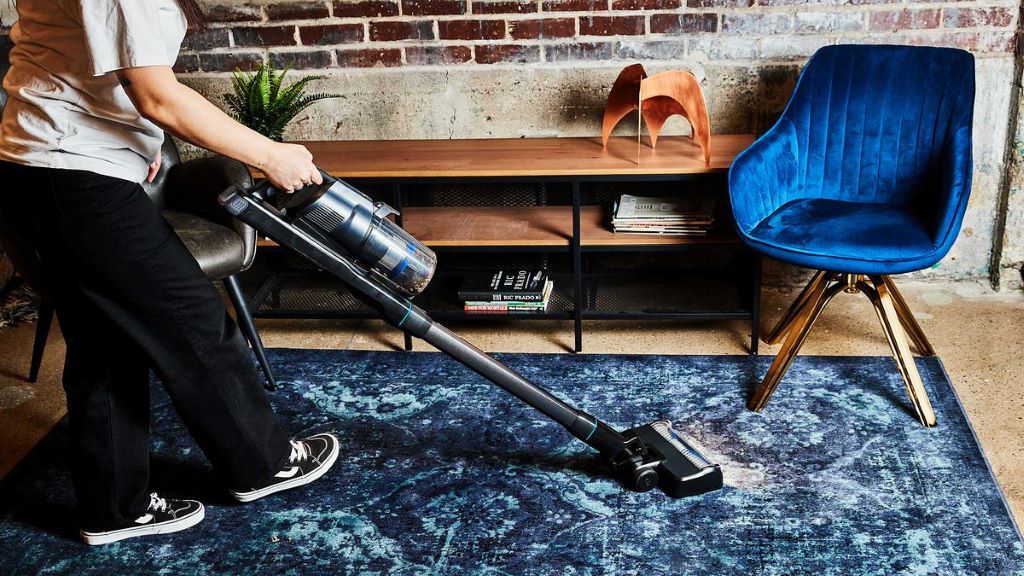 Lightweight cordless stick vacuum transitioning from carpet to hard floors, highlighting versatile cleaning for Arizona households