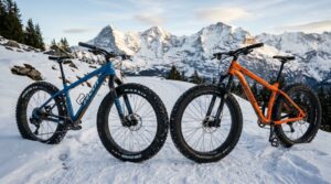 Two fat tire mountain bikes parked side by side on a snowy mountain trail.